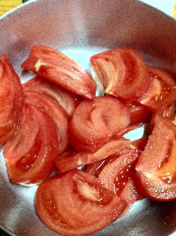 くし切りにしたトマトを鍋に入れる